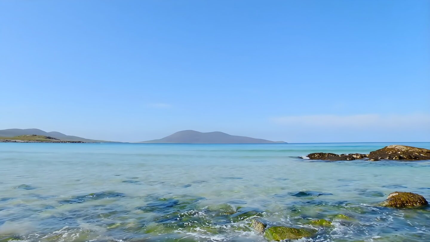 Clear turquoise sea and distant islands under a blue sky